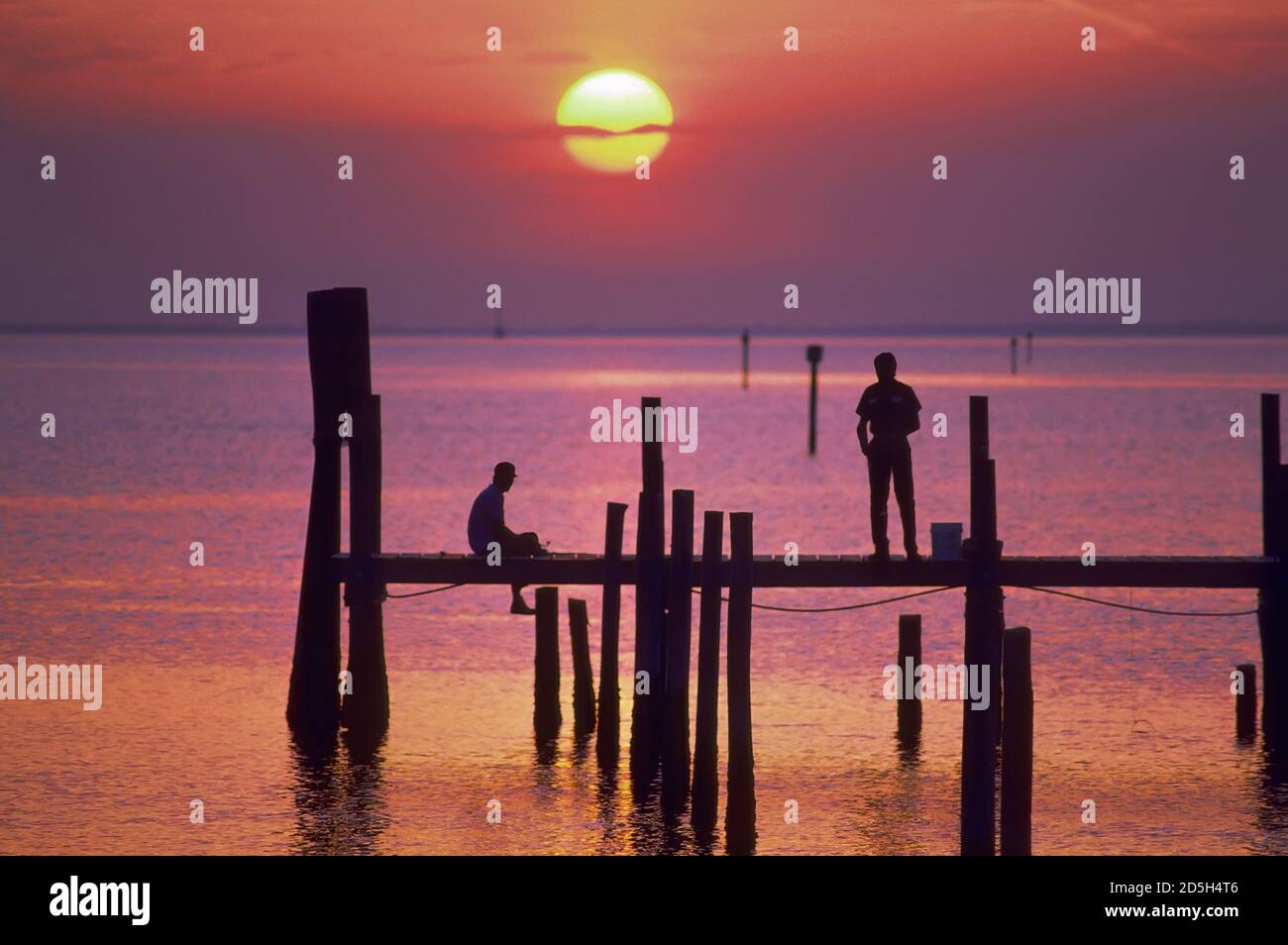 Sunset Naples Florida with people fishing on a pier Stock Photo