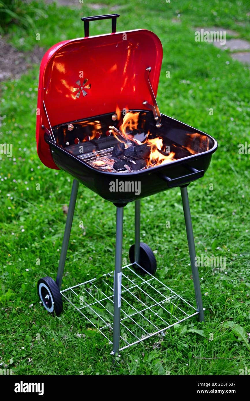 Garden grill with burning wood and charcoal. Summer barbecue in the garden. Stock Photo