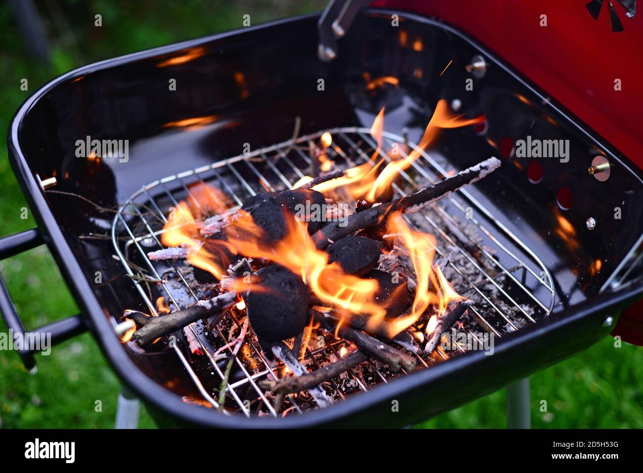 Garden grill with burning wood and charcoal. Summer barbecue in the garden. Stock Photo