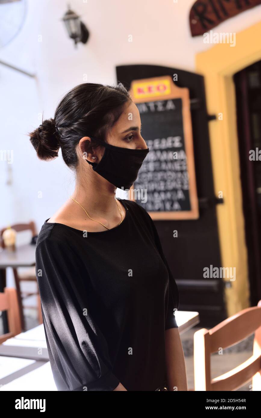 Attractive young woman wearing face mask for covid precautions Stock Photo