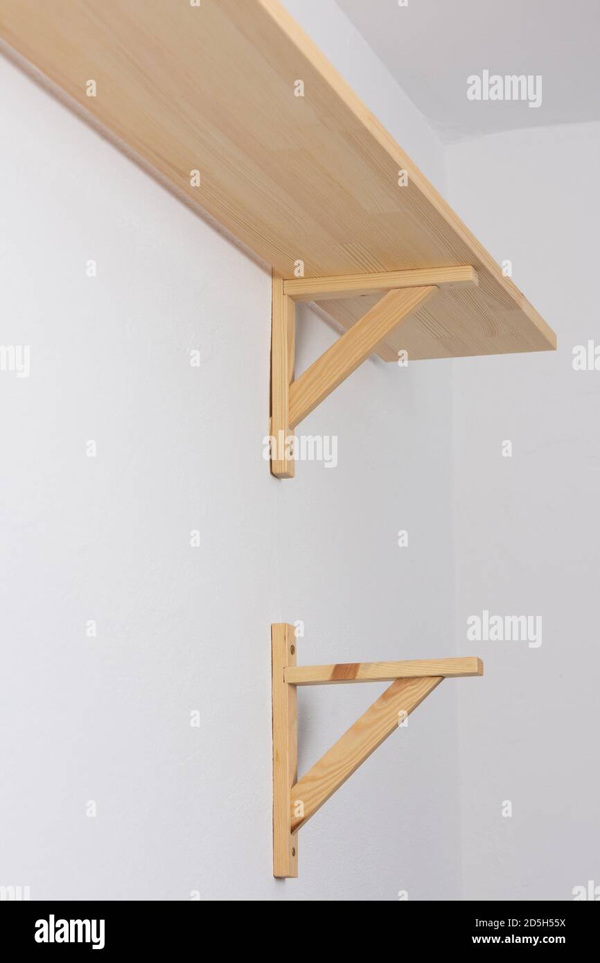 The process of attaching a wooden shelf to the wall, shelf corners