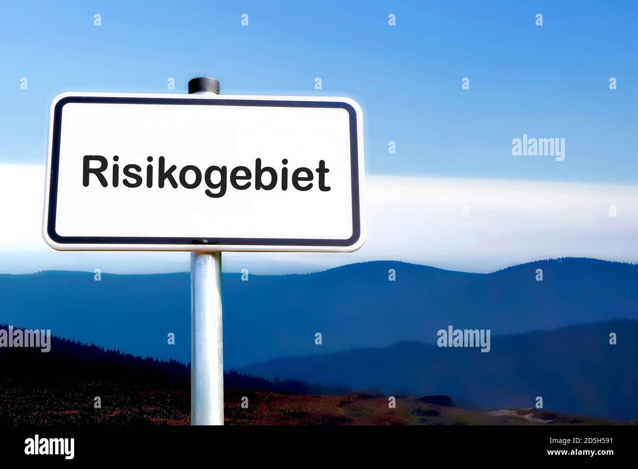 Sign with the inscription 'Risk area' (Risikogebiet). Due to many new corona infections, areas are designated as risk areas. Stock Photo