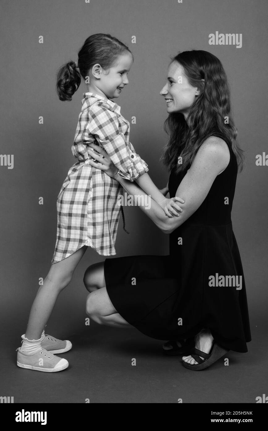 Mother and daughter bonding together against gray background Stock Photo