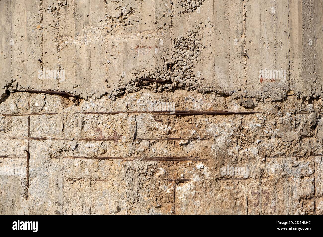 Reinforced concrete with damaged and rusty steel reinforcement. Old distressed wall texture background, steel bars and mesh visible corrosion Stock Photo