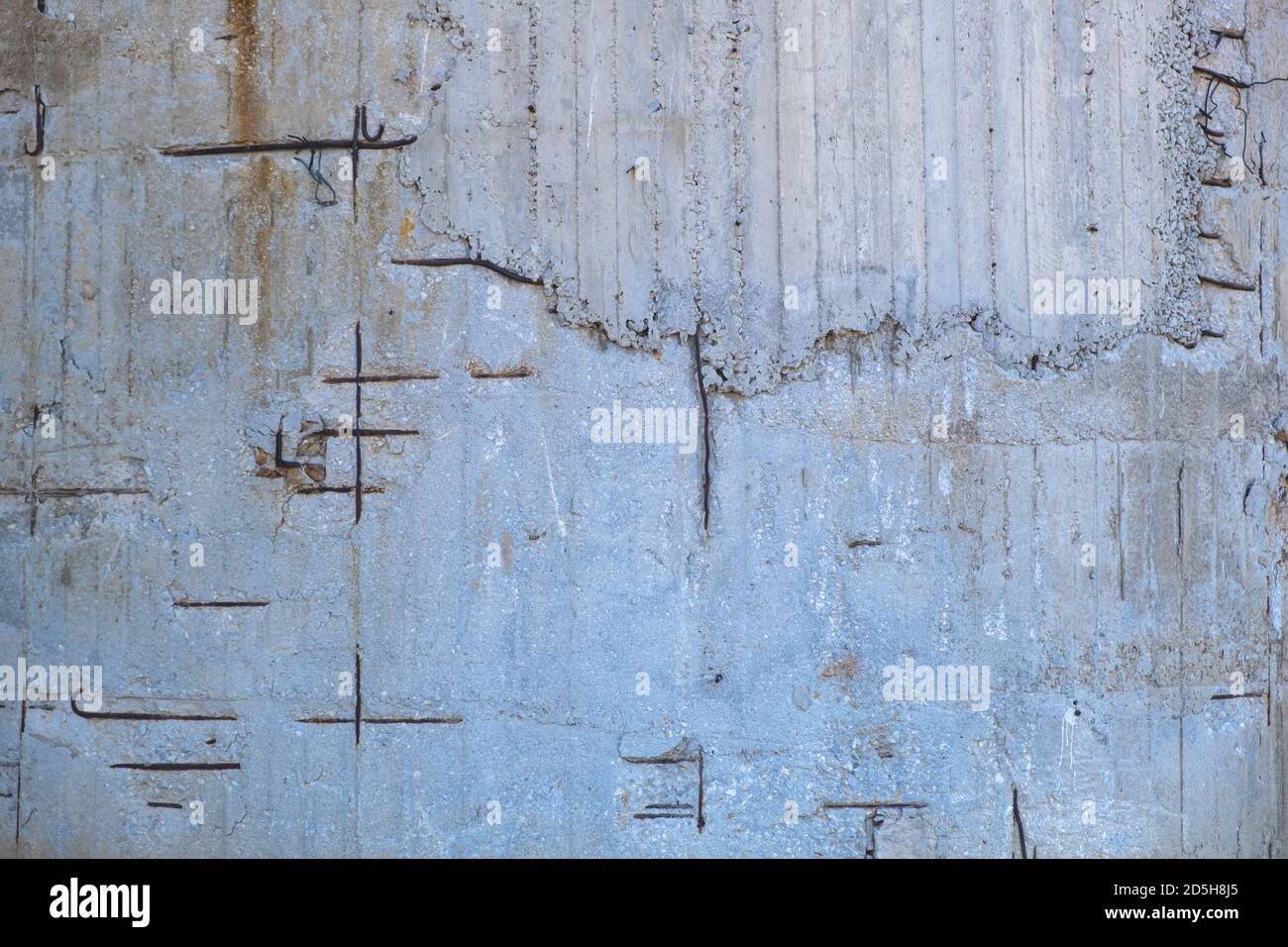 Reinforced concrete with damaged and rusty steel reinforcement. Old distressed wall texture background, steel bars and mesh visible corrosion Stock Photo