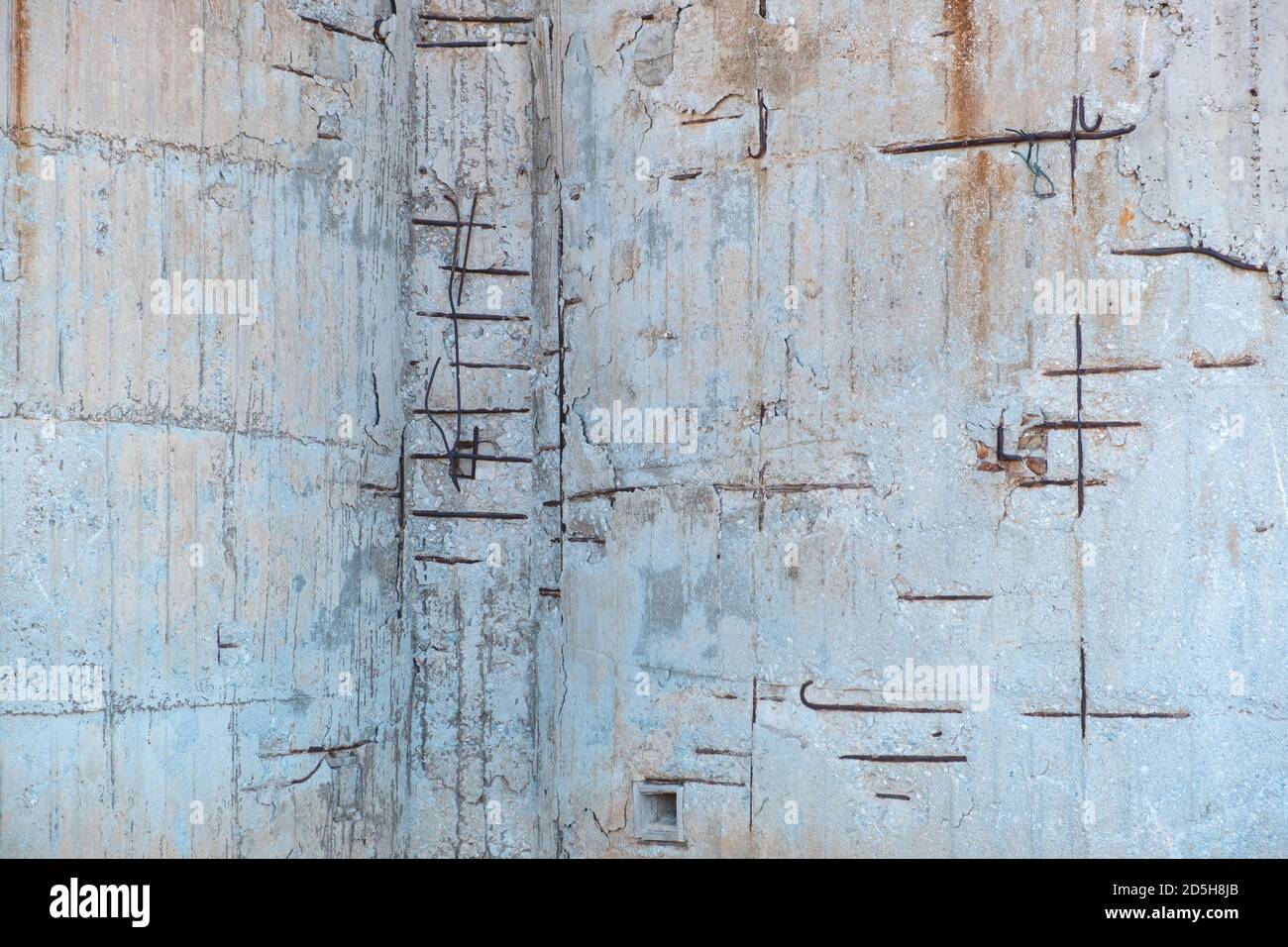 Reinforced concrete with damaged and rusty steel reinforcement. Old distressed wall texture background, steel bars and mesh visible corrosion Stock Photo