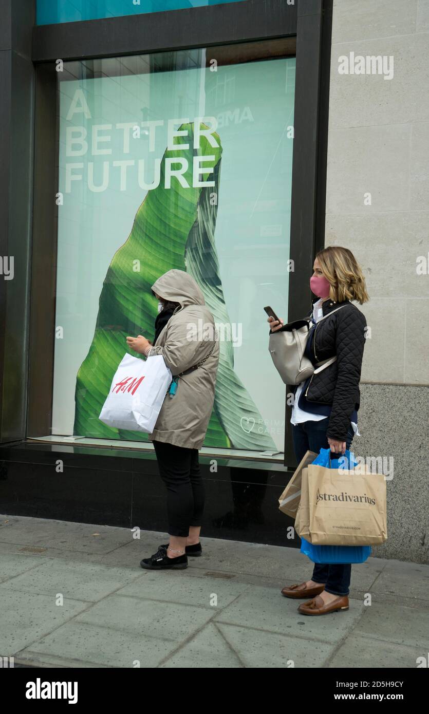 Shoppers in Oxford Street, with signs advising to keep safe social