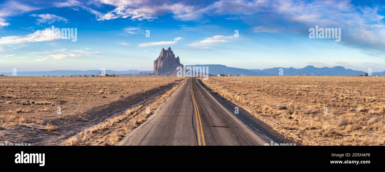 Panoramic View of a road in a dry desert with Shiprock Stock Photo Alamy