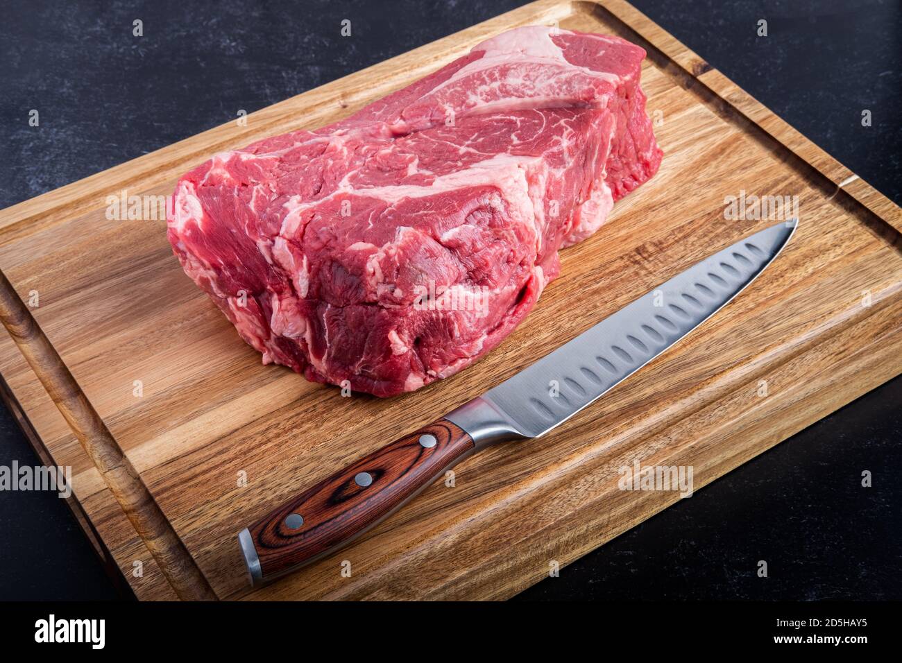 Boneless Beef Chuck Roast on a cutting board with a carving knife in the kitchen Stock Photo