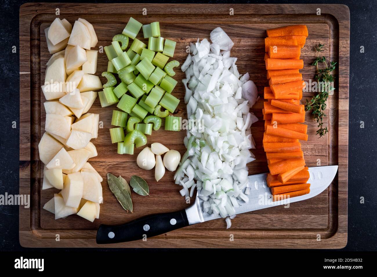 Raw carrots, onions potatoes, celery with garlic, thyme and bay leaves