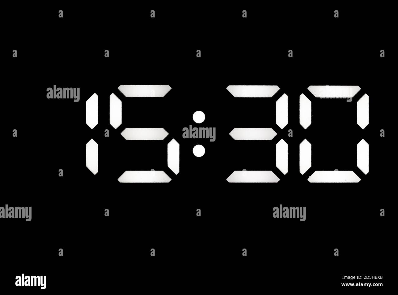 Real white led digital clock on a black background showing time 15 