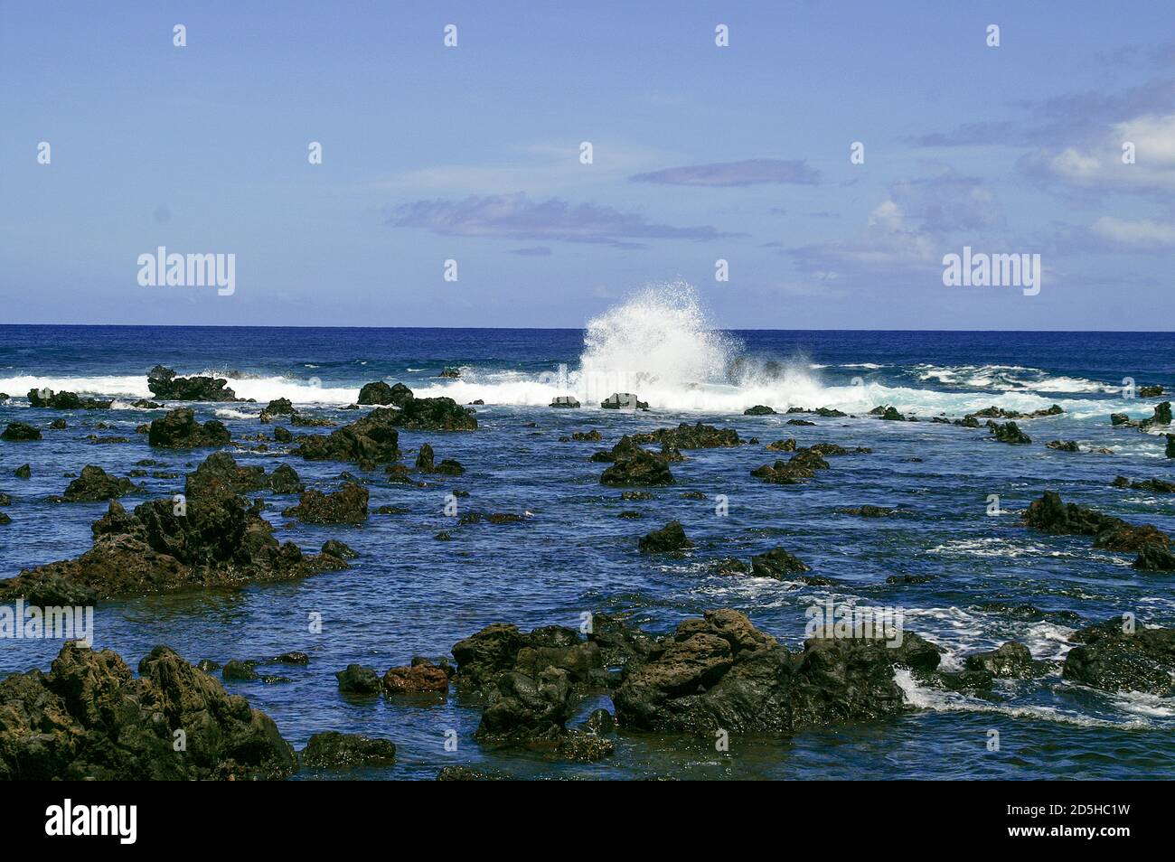 Waves breaking on the rough rocks. Rocky shore line. Stock Photo