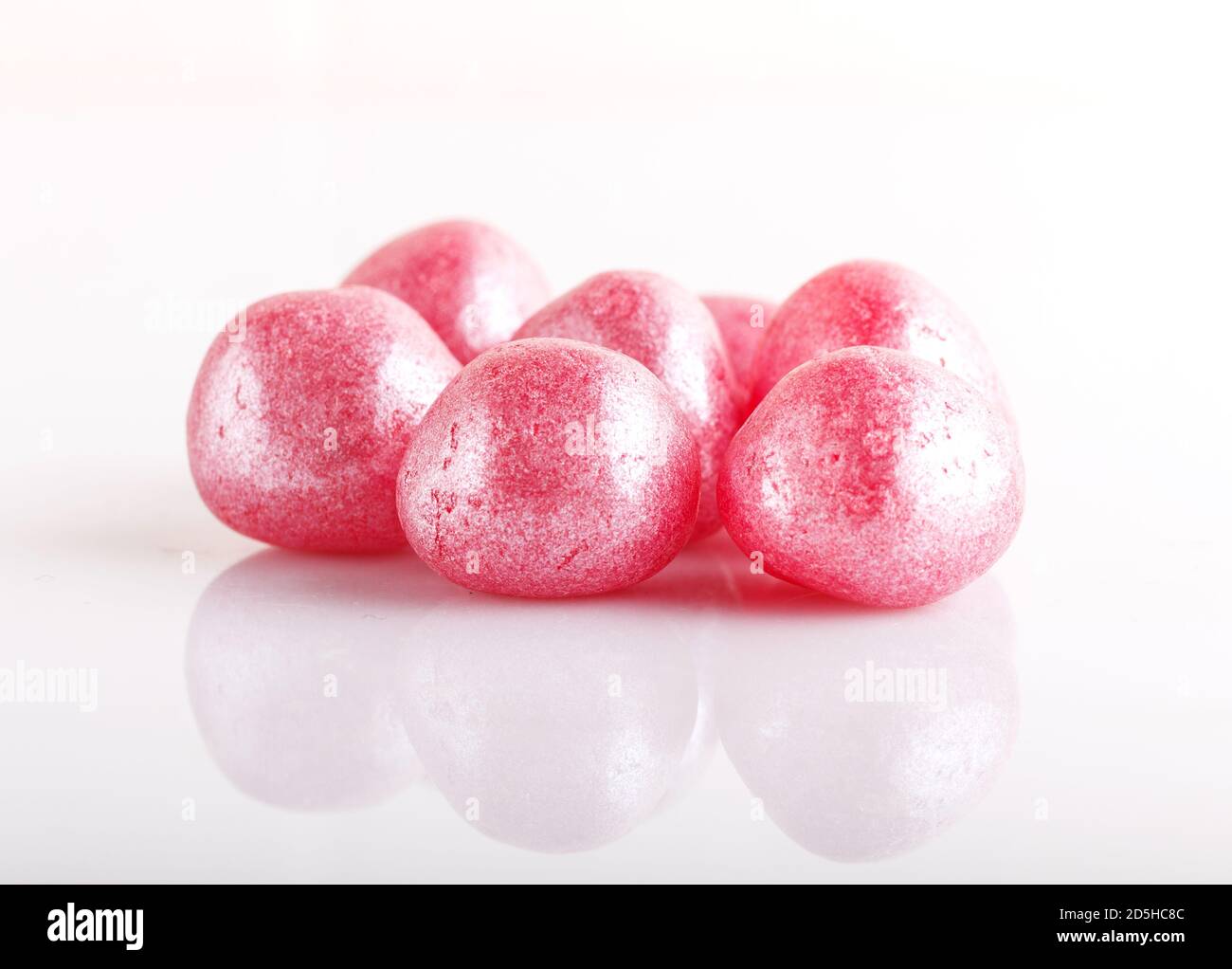 Heap of pink hard sugar candies isolated on white background Stock