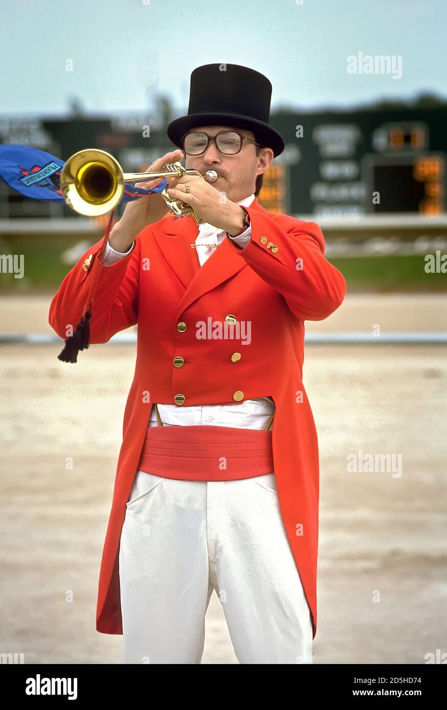 Male with trumpet sounds the bugle call at the beginning of a horse