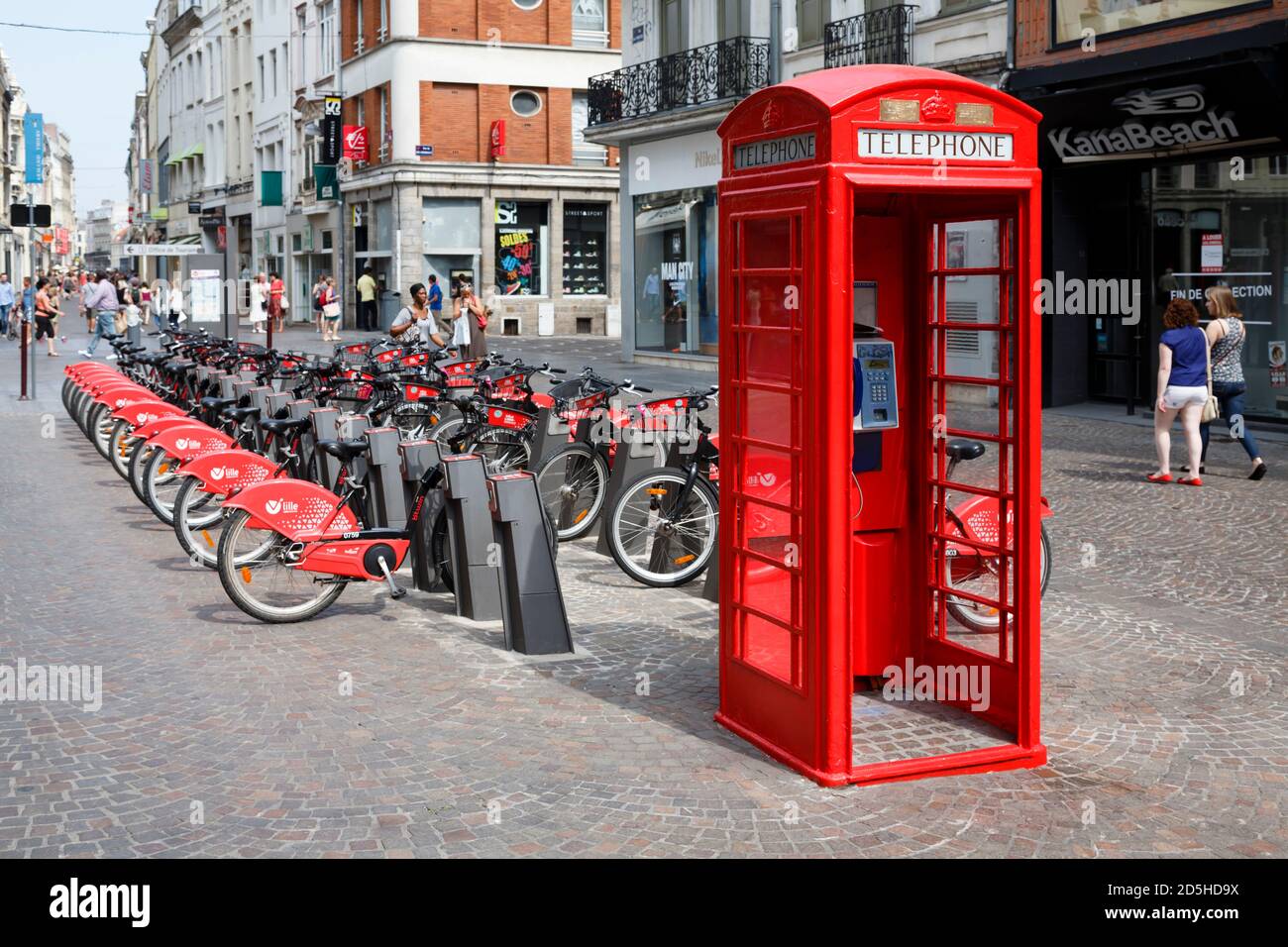 LILLE, FRANCE - July 18, 2013. Red British telephone box and free bike rental station in a street in Lille, France Stock Photo