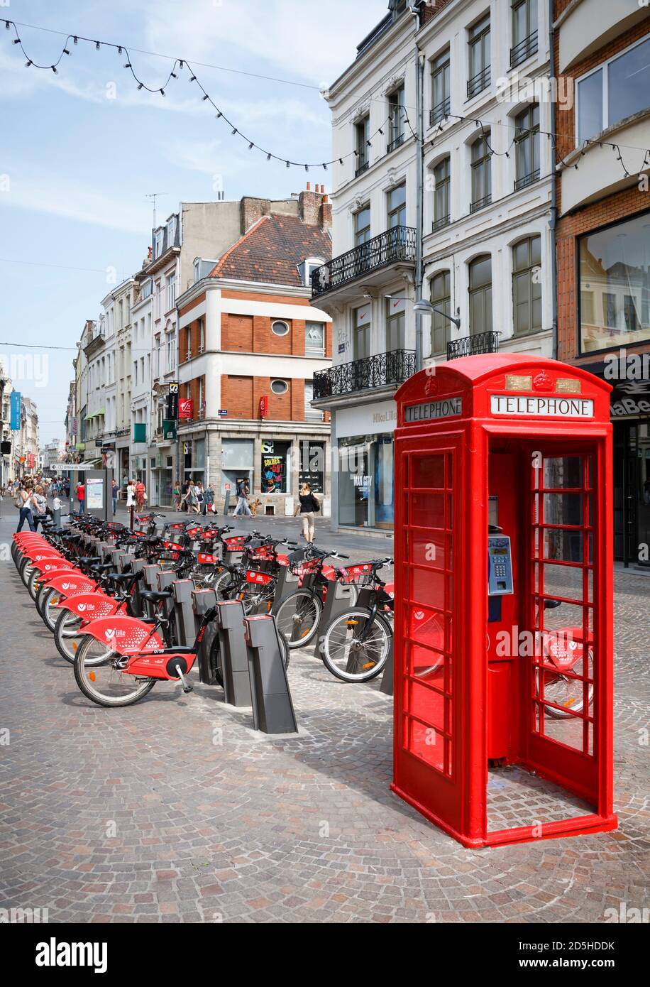 LILLE, FRANCE - July 18, 2013. Free bike rental station and red British telephone box in a street in Lille, France Stock Photo