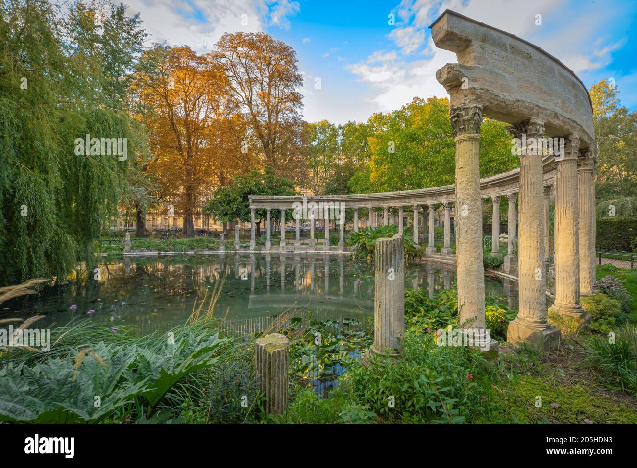 Paris, France - 10 11 2020: Golden hour in Parc Monceau in autumn. Oval basin bordered by a Corinthian colonnade Stock Photo
