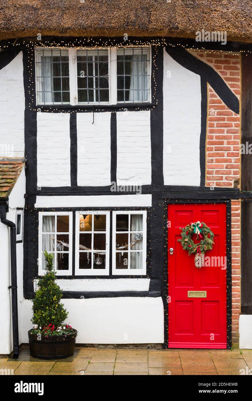 WINSLOW, UK - December 26, 2019. Christmas decorations outside old thatched cottage house in UK, winter street scene Stock Photo