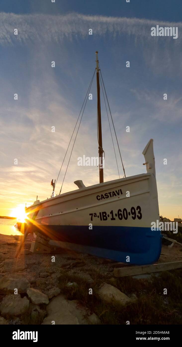 Balearic traditional fishing boat, called llaut, on a dry dock in Ses Salines Natural Park at sunset (Formentera, Pityuses, Mediterranean Sea, Spain) Stock Photo