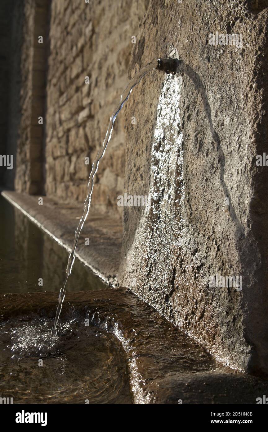 Ronda, España, Hiszpania, Spain, Spanien; A narrow stream of water flowing from a pipe in the wall. Ein Wasserstrahl fließt aus einem Rohr in der Wand Stock Photo