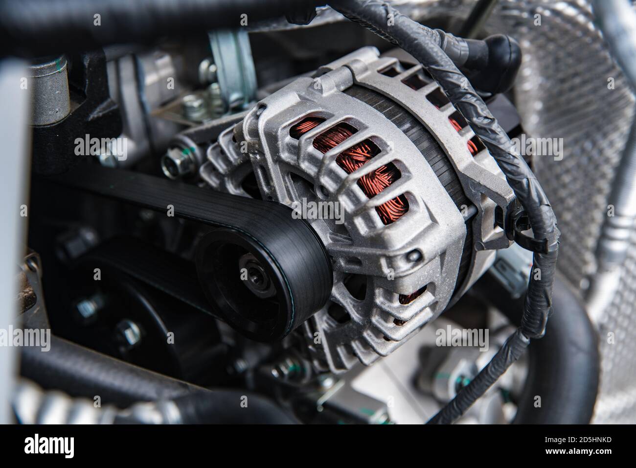 new car generator and belt tensioned on the shaft at shallow depth of