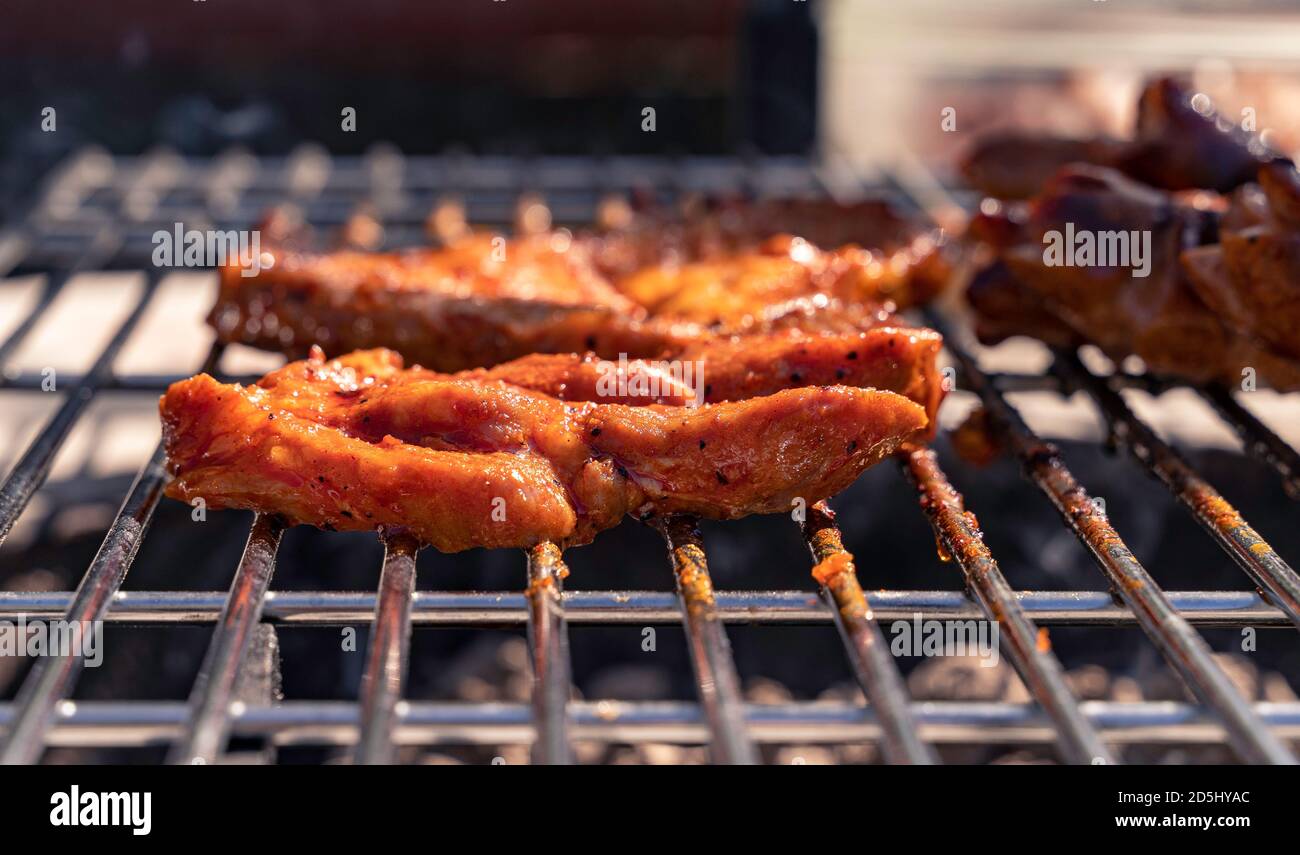 Pork steaks cooking over grill. Side view. Stock Photo