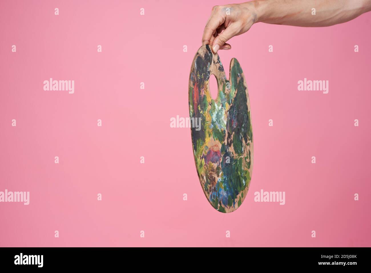 Palette with paints in hand artist drawing pink background occupation Stock Photo