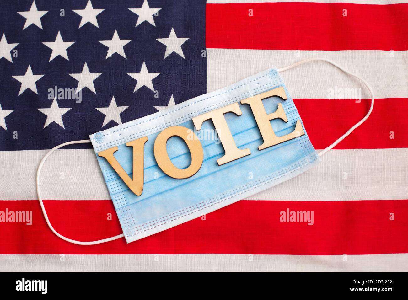 Word VOTE on Medical protective mask against the virus on the american flag background. Electoral vote. US elections. Stock Photo