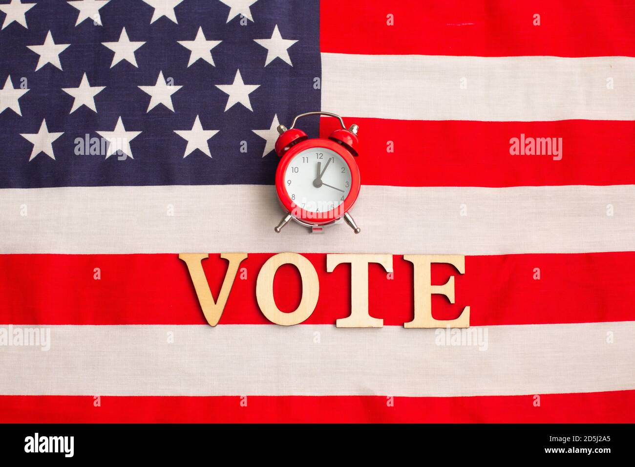 Alarm clock on American flag. President elections. Patriotism and independence. Time to vote. Electoral vote. US elections. Stock Photo