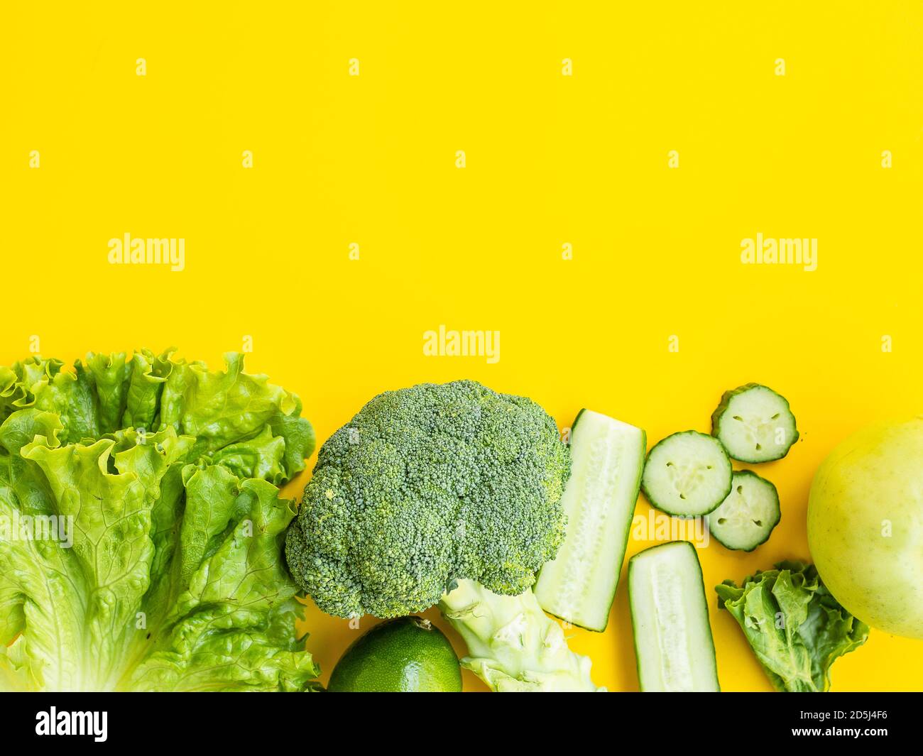 Healthy food and dieting concept. Green vegetables isolated on yellow ...