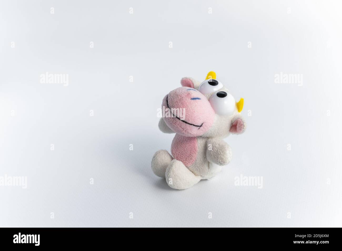 Children's soft toy bull, on a white background. A cute toy for funny children's games. The symbol of the new 2021. Close up. Space for text. Stock Photo