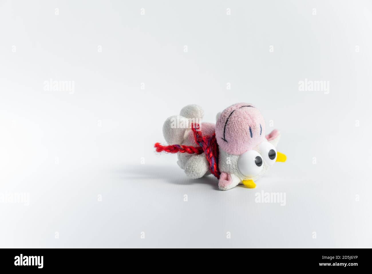 A cute toy for funny children's games. Children's soft toy bull in a red scarf, on a white background. The symbol of the new 2021. Close-up.Copy space Stock Photo