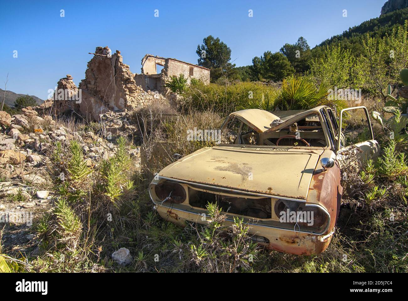 Closeup of an old abandoned car in a valley surrounded by building ...