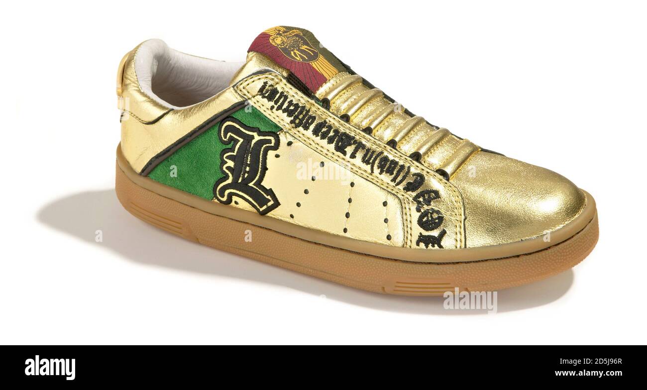 L.A.M.B. metallic gold sneaker with green accent photographed on a white  background Stock Photo - Alamy