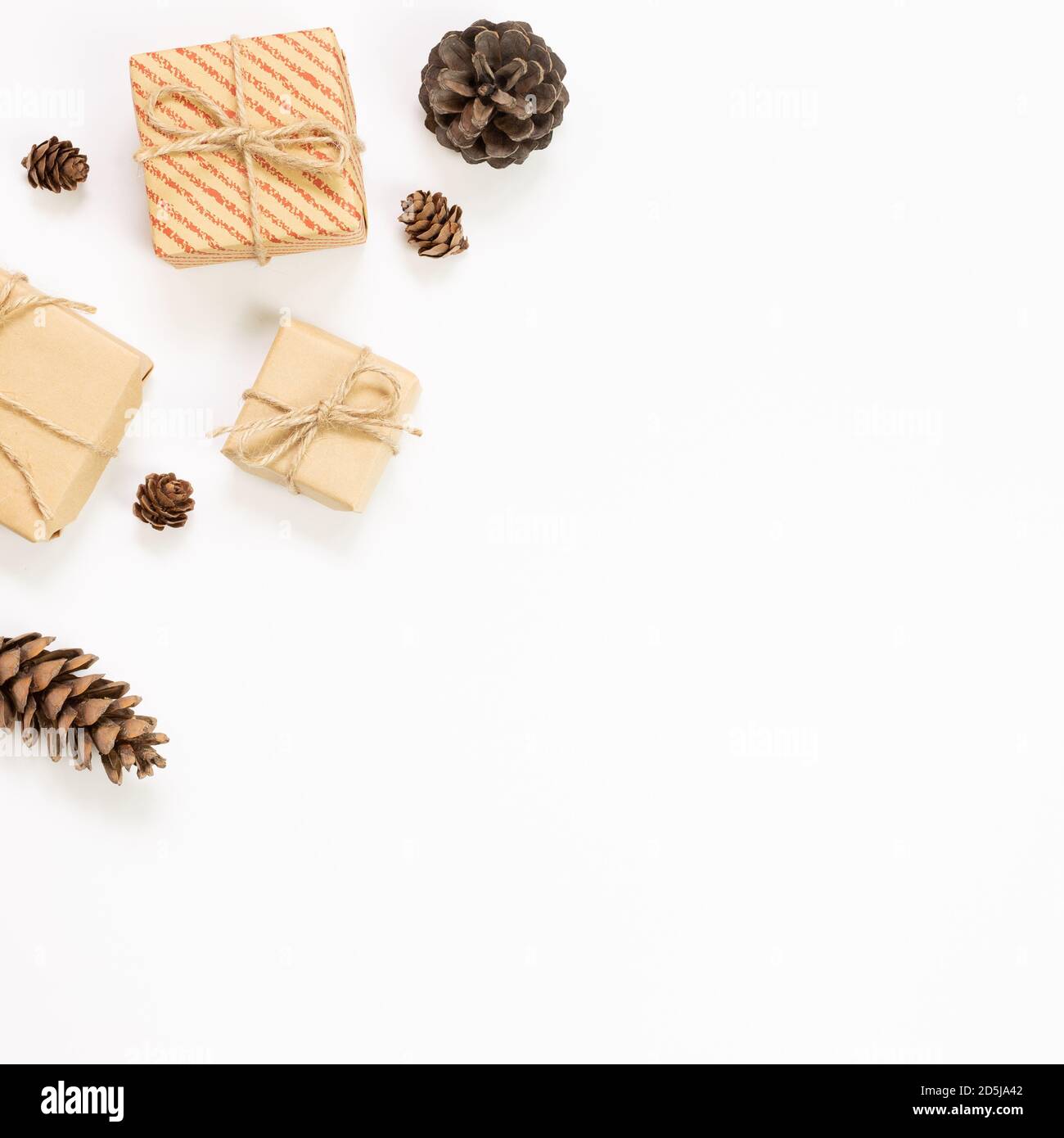 Gift boxes with pine cones on white background. Autumn and winter concept. flat lay, top view, copy space Stock Photo