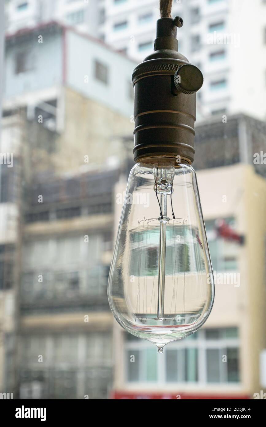 The close up of vintage light bulb hanging with downtown background Stock Photo Alamy