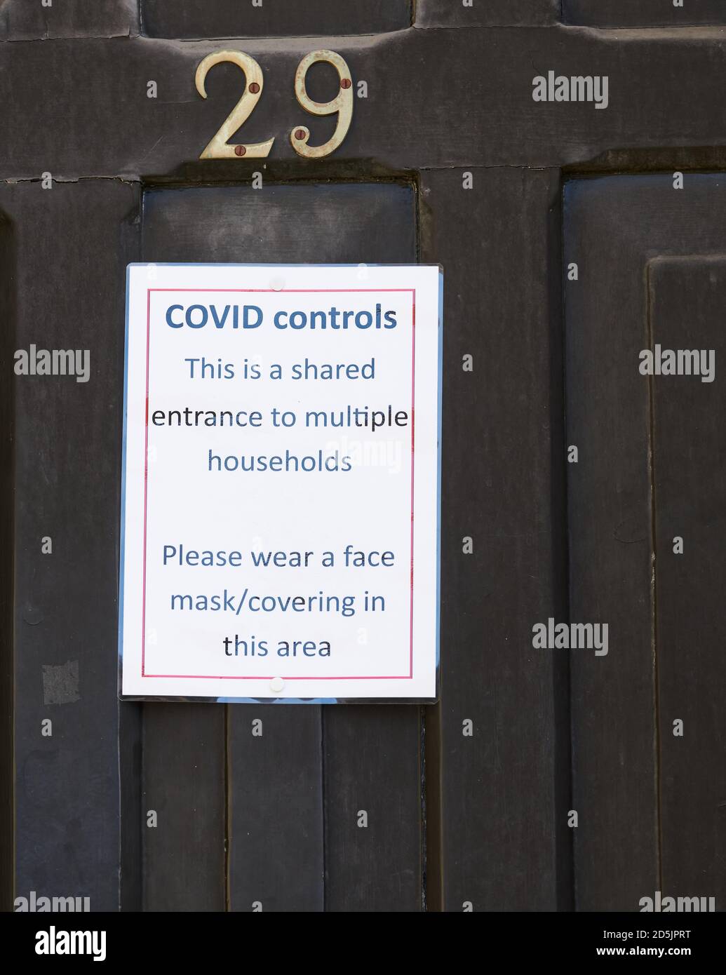 Notice on a door of a house with multiple households at Cambridge, England, about covid controls, October 2020. Stock Photo