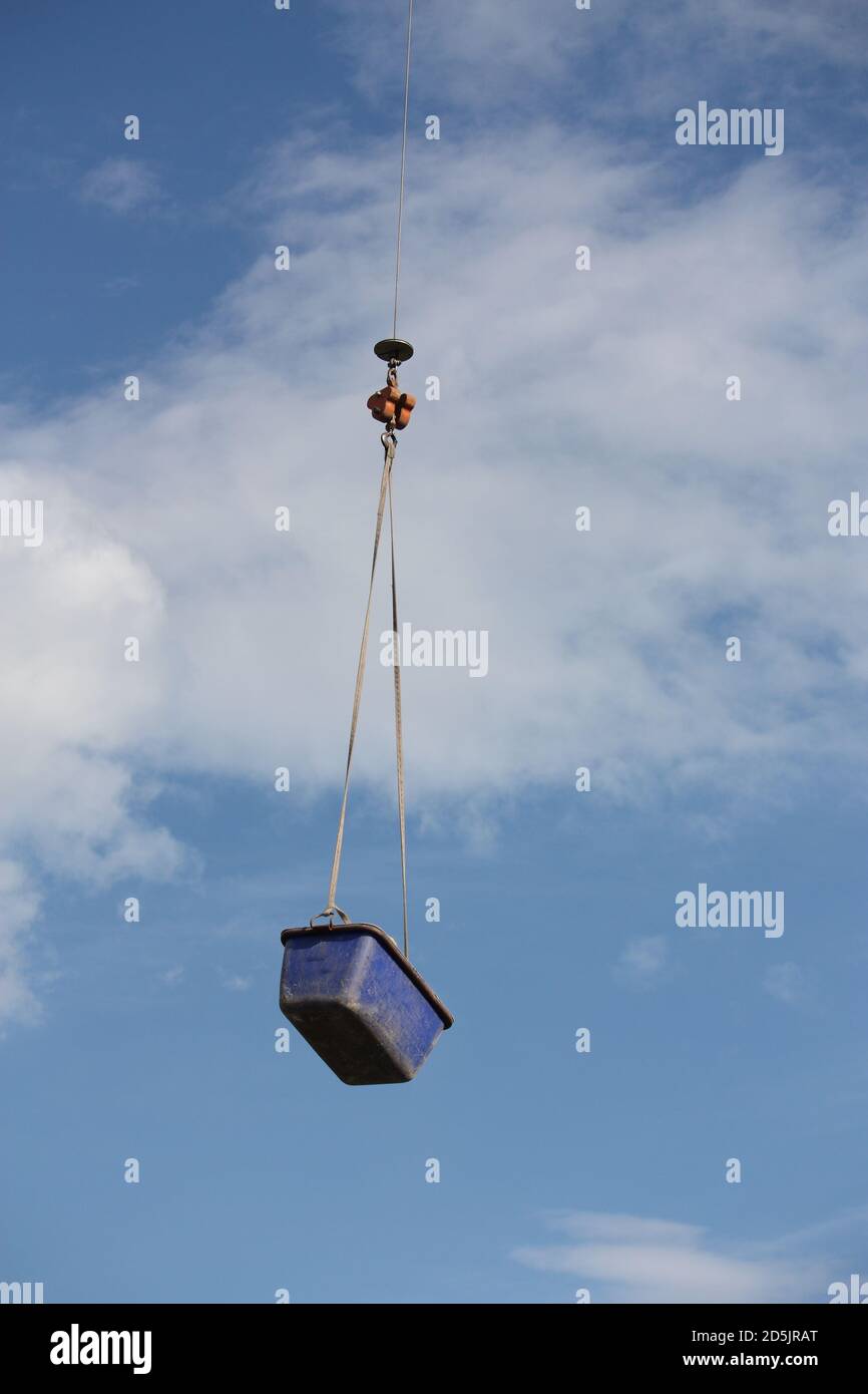 Low angle shot of a crane lifting a huge box under a cloudy sky Stock ...