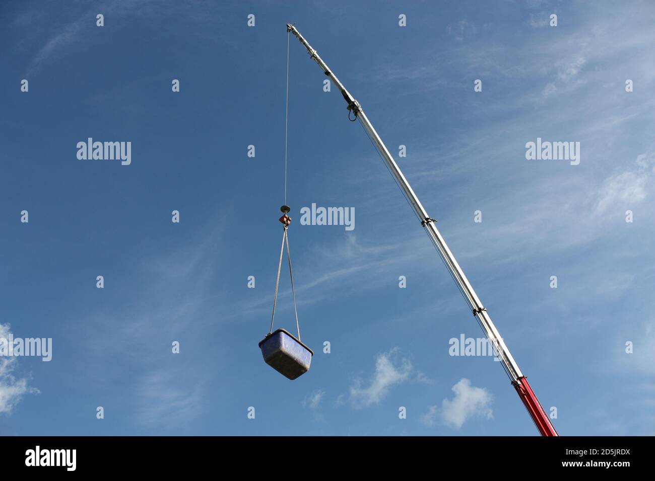 Low angle shot of a crane lifting a huge box under a cloudy sky Stock ...