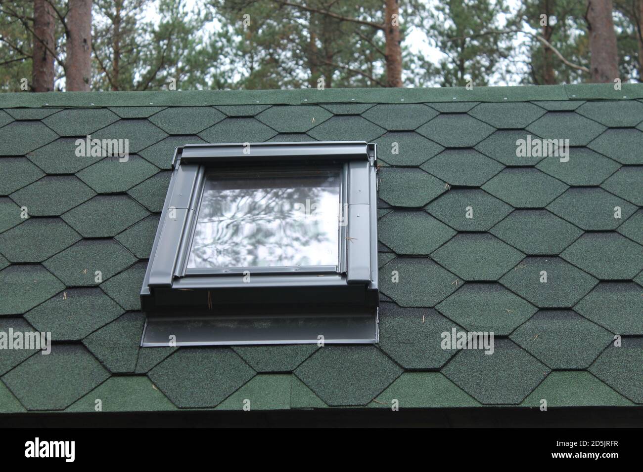Green shingles roof top with sky light window close up Stock Photo