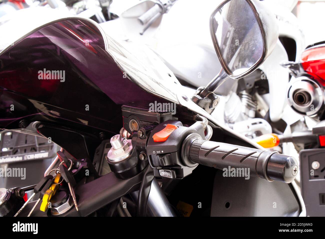 Right side of motorcycle steering wheel close-up. The handle of the gas sportbike, with windshield, mirror, control buttons for headlights, turn signa Stock Photo