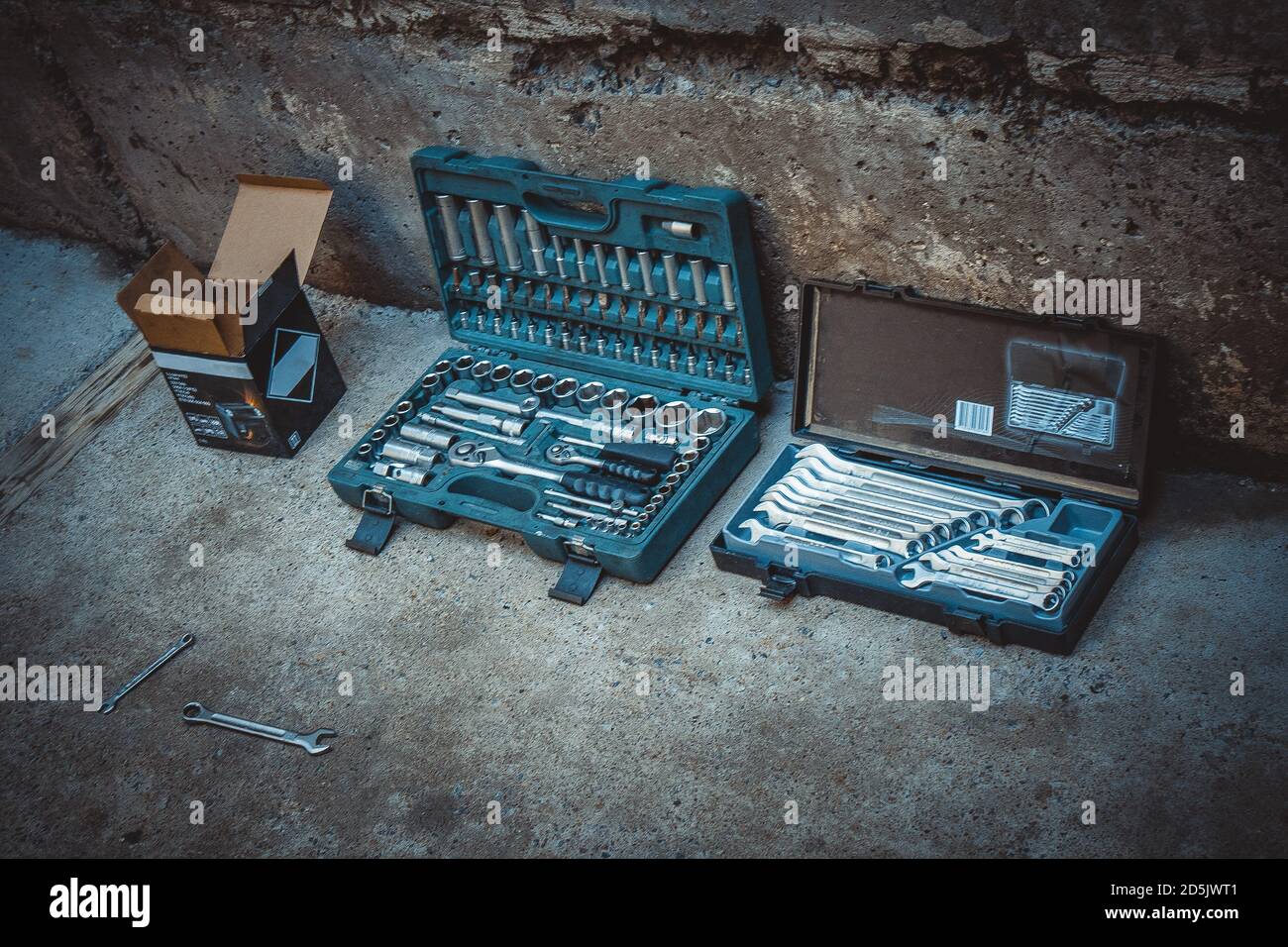 Professional mechanic tool kit in a box for repairing motorcycles and equipment. Closeup chrome steel tool on concrete in a garage. Collection of diff Stock Photo