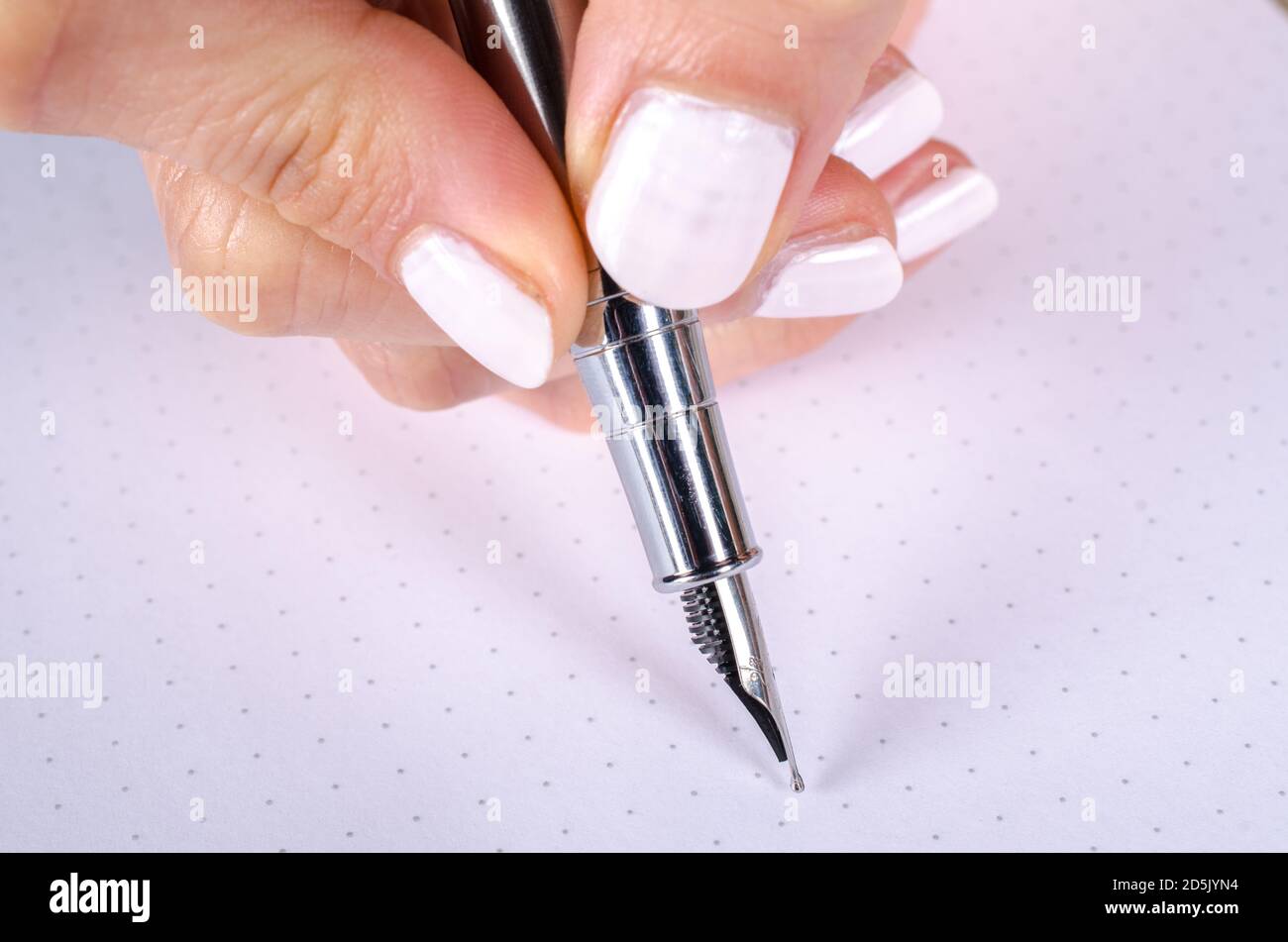 FEmale hand holding a slim fountain pen Stock Photo Alamy