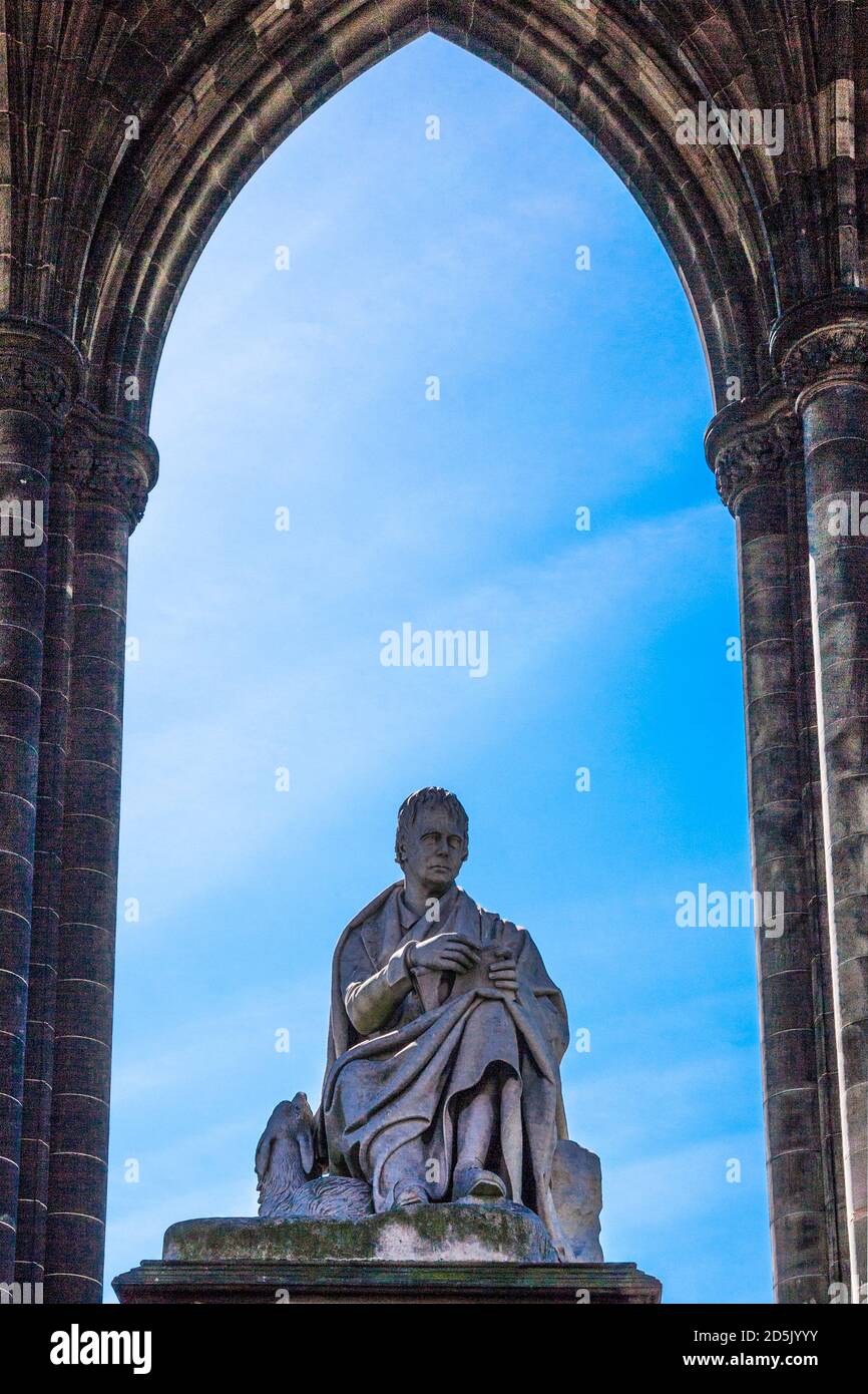 The Statue of Sir Walter Scott and his dog, framed by the Scott Monument in Edinburgh. Stock Photo