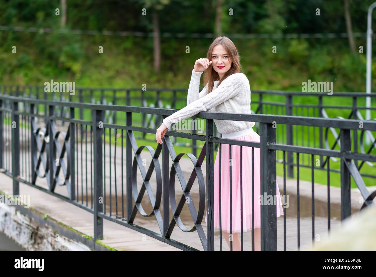 Girl on the bridge through small river Stock Photo - Alamy