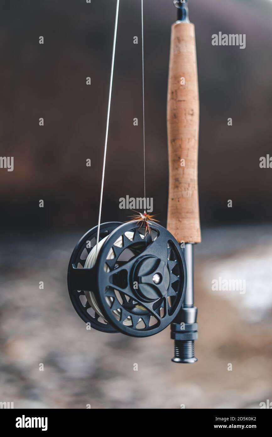 Fly fishing reel with rod in nature blur background Stock Photo