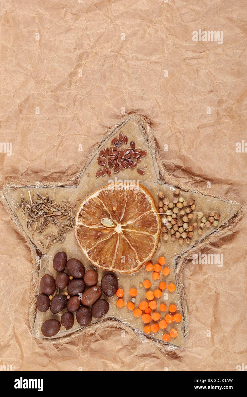 Dried lemon, coffee beans, cereals in a rope star. Christmas theme. Stock Photo