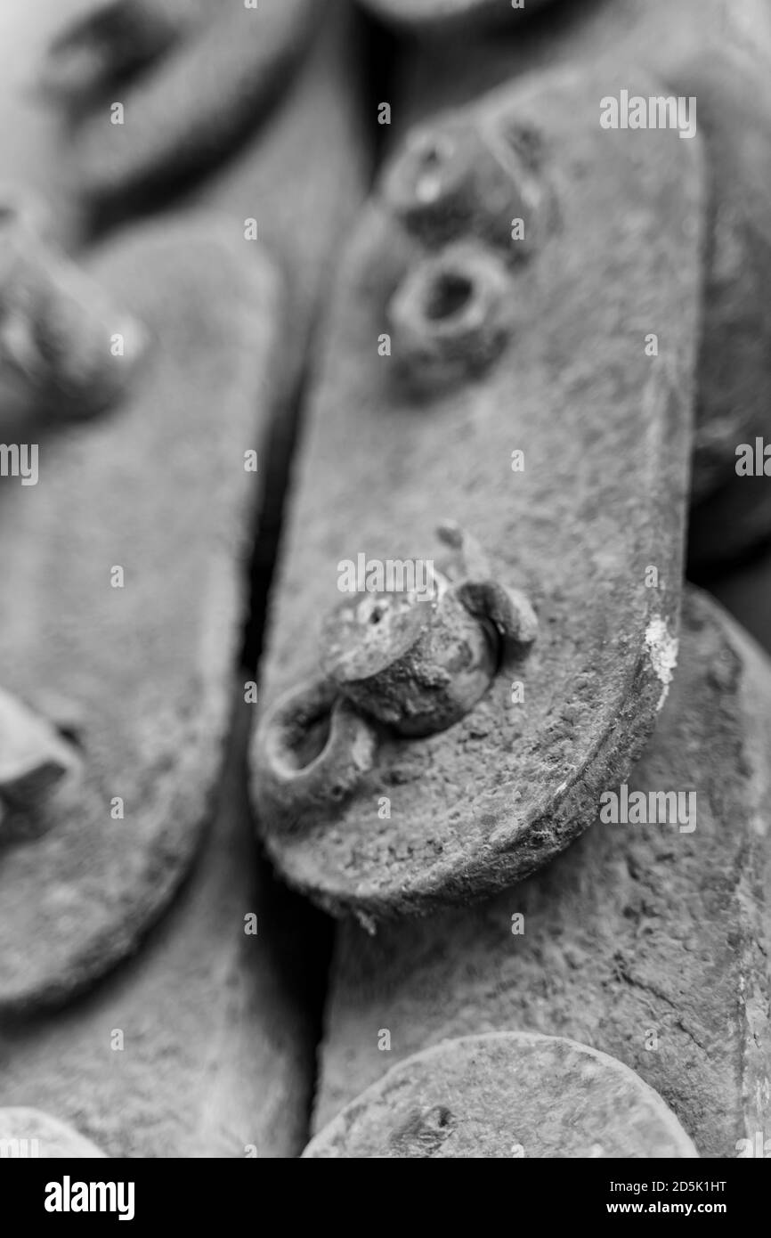 Unsaturated vertical photo of old rusty iron pieces linked together Vintage and antique concept Stock Photo