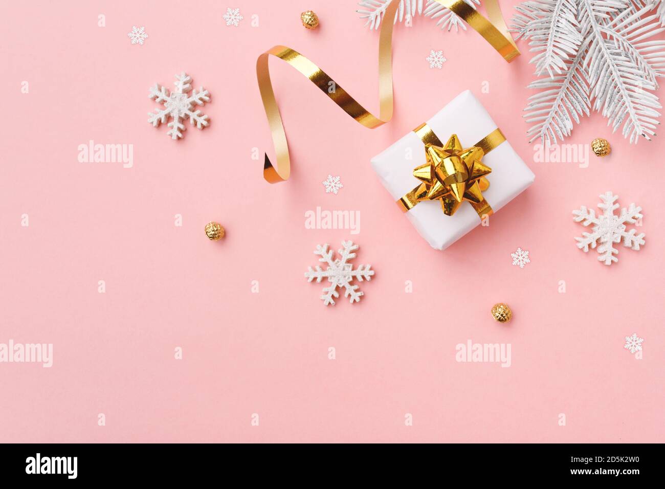 Christmas gift with snowflakes and decoration on pink pastel background Stock Photo