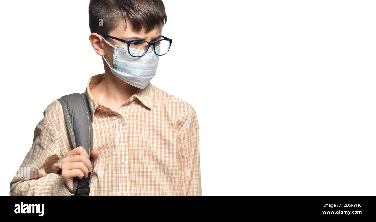 Portrait of a schoolboy in glasses and a protective mask with a strained look on a white isolated background Stock Photo